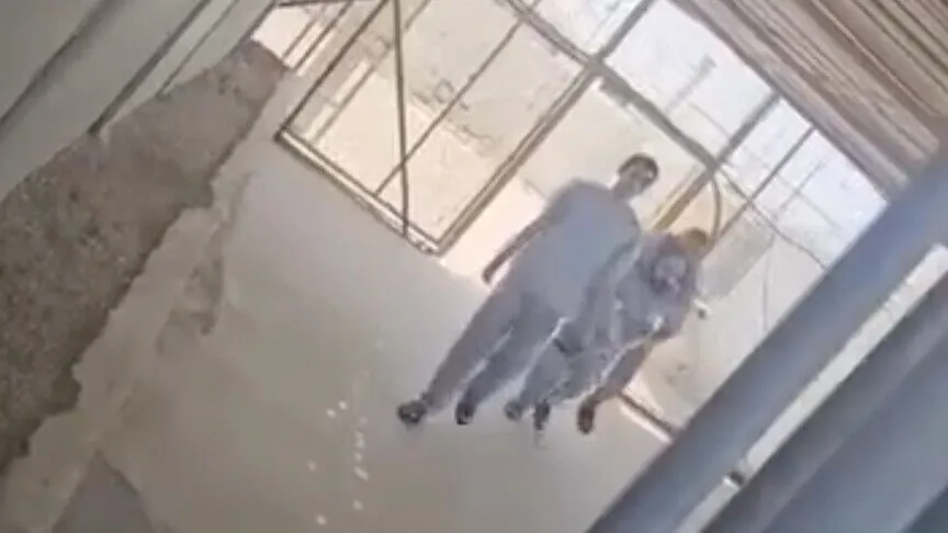 أسير فلسطيني يحمل رفيقه العاجز عن المشي بعد إفراج إسرائيل عنهما